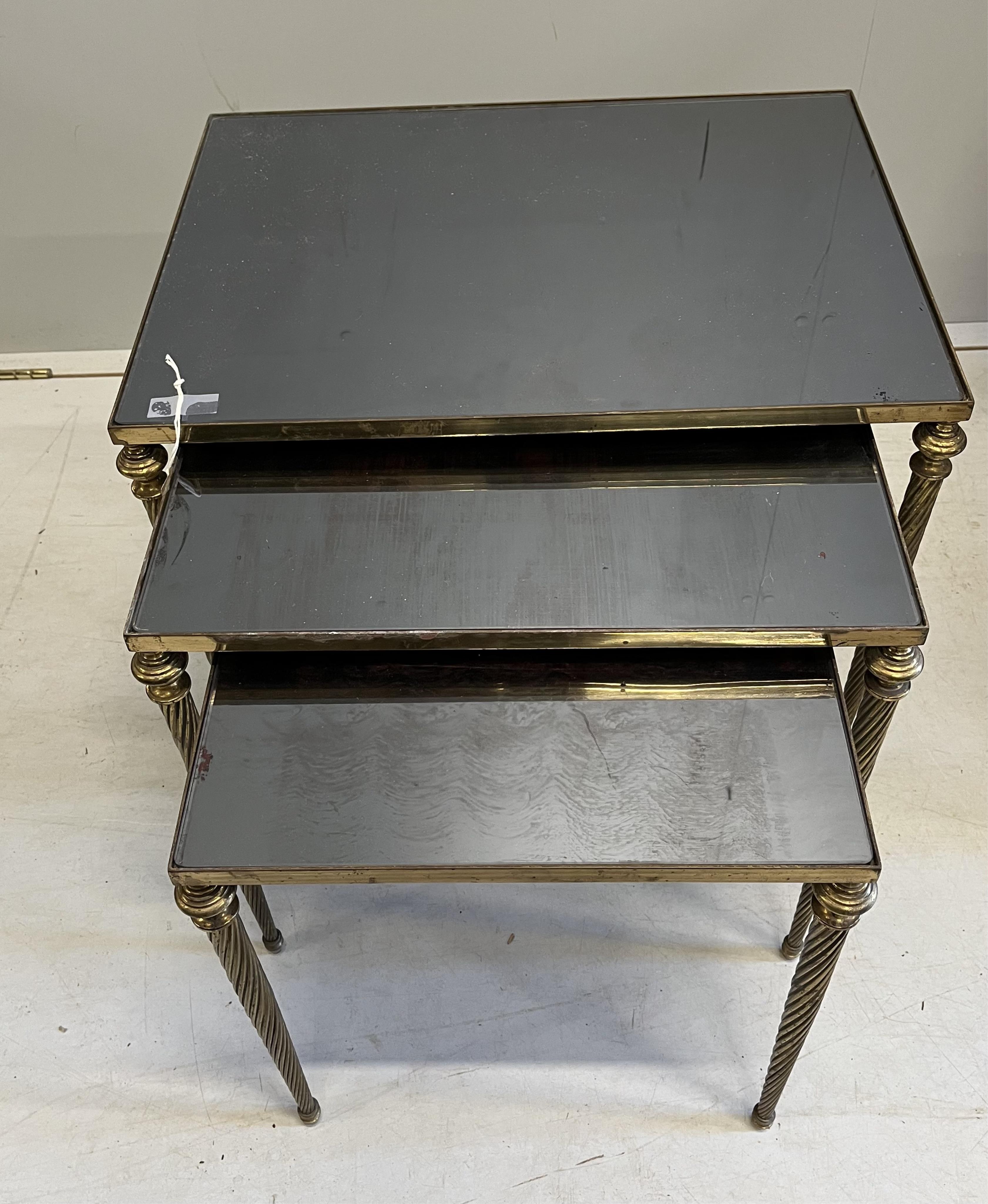 A nest of three brass and smoked glass tables, width 54cm, depth 40cm, height 45cm